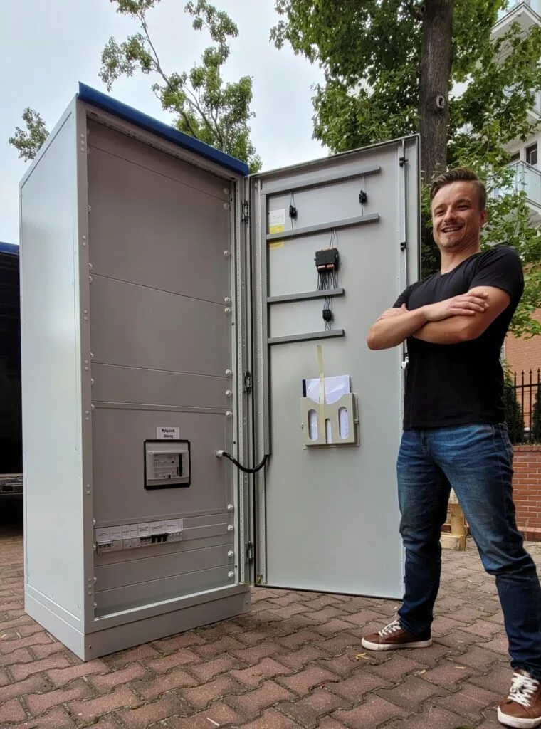 Człowiek obok sprefabrykowanej rozdzielnicy elektrycznej